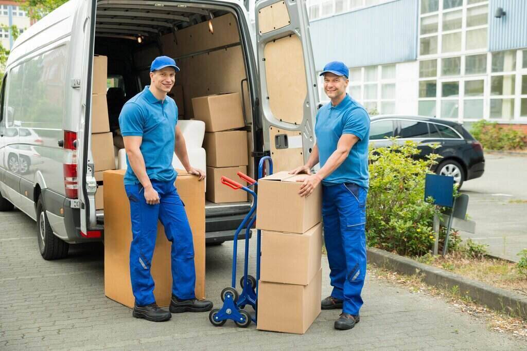 rsz two happy male movers in front of truck with stack of cardboard boxes